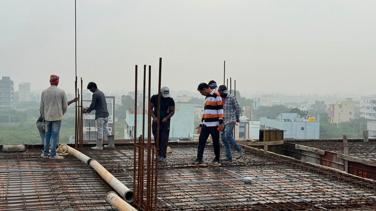 Workers tying reinforcement steel on a rooftop slab
